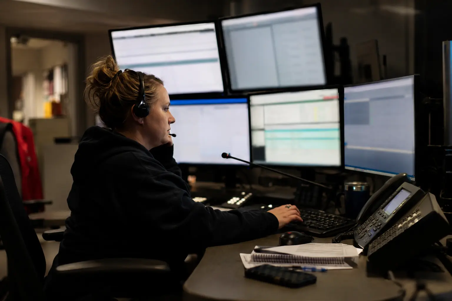 A public-safety telecommunicator working at an overnight dispatch console